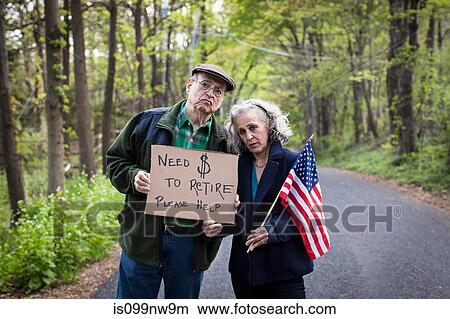 Picture - Senior couple holding sign in forest, portrait. Fotosearch