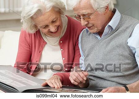 Senior couple looking at photo album View Large Photo Image Picture - Senior couple looking at photo album. Fotosearch