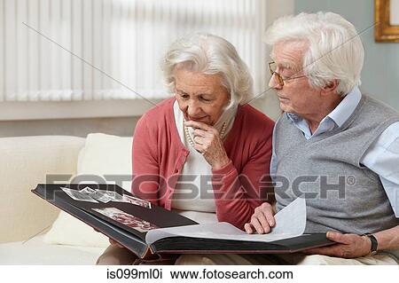 Senior couple looking at photo album View Large Photo Image Stock Image - Senior couple looking at photo album. Fotosearch