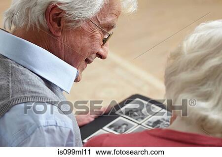 Senior couple looking at photo album View Large Photo Image Stock Image - Senior couple looking at photo album. Fotosearch