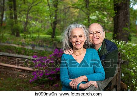 Senior couple sitting in forest, smiling, portrait View Large Photo Image Picture - Senior couple sitting in forest, smiling, portrait. Fotosearch