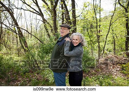 Senior couple standing together in forest, portrait View Large Photo Image Stock Image - Senior couple standing together in forest, portrait. Fotosearch