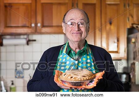 Senior man holding freshly baked pie, portrait View Large Photo Image Stock Image - Senior man holding freshly baked pie, portrait. Fotosearch
