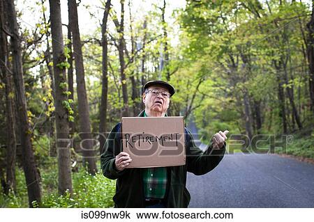 Senior man holding sign in forest, portrait View Large Photo Image Stock Image - Senior man holding sign in forest, portrait. Fotosearch