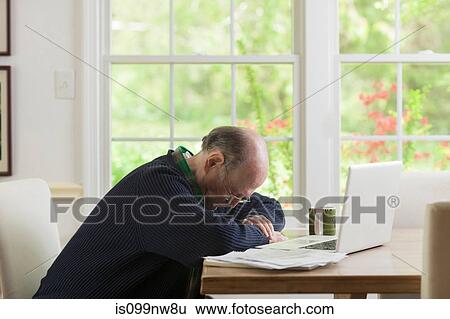 Senior man looking down at table View Large Photo Image Stock Photograph - Senior man looking down at table. Fotosearch