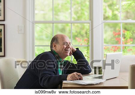 Senior man using laptop at home, smiling View Large Photo Image Stock Photo - Senior man using laptop at home, smiling. Fotosearch