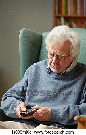 Stock Image - Senior man using remote control. Fotosearch