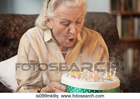 Senior woman blowing out birthday candles View Large Photo Image Stock Photography - Senior woman blowing out birthday candles. Fotosearch