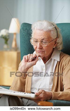 Senior woman doing crossword View Large Photo Image Picture - Senior woman doing crossword. Fotosearch