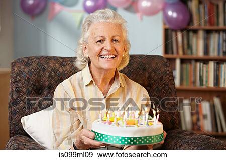 Senior woman holding birthday cake, portrait View Large Photo Image Stock Photo - Senior woman holding birthday cake, portrait. Fotosearch
