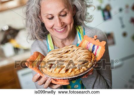 Stock Photo - Senior woman holding freshly baked pie. Fotosearch