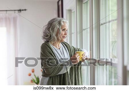 Senior woman looking out of window View Large Photo Image Stock Photo - Senior woman looking out of window. Fotosearch
