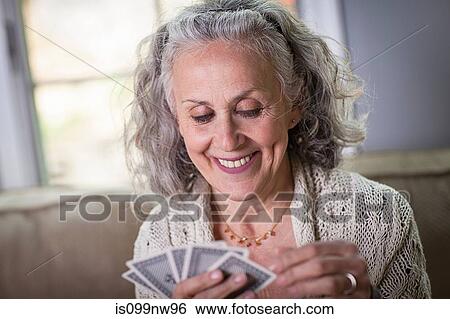 Senior woman playing card game at home View Large Photo Image Stock Photograph - Senior woman playing card game at home. Fotosearch