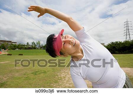 Senior woman stretching in a park View Large Photo Image Stock Photograph - Senior woman stretching in a park. Fotosearch