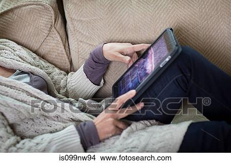 Senior woman using digital laptop on sofa, mid section View Large Photo Image Picture - Senior woman using digital laptop on sofa, mid section. Fotosearch