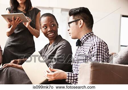 Picture - Three business people in meeting. Fotosearch