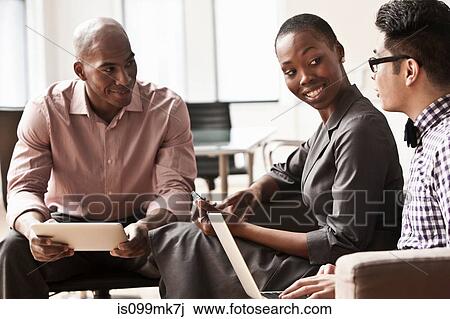 Stock Image - Three business people in meeting. Fotosearch