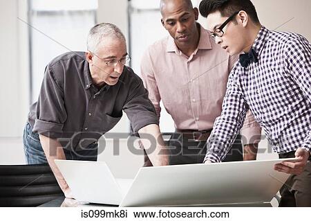 Stock Image - Three business people in meeting. Fotosearch