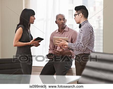Stock Image - Three business people in meeting. Fotosearch