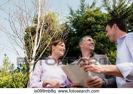 Three businesspeople with document View Large Photo Image Stock Photography - Three businesspeople with document. Fotosearch