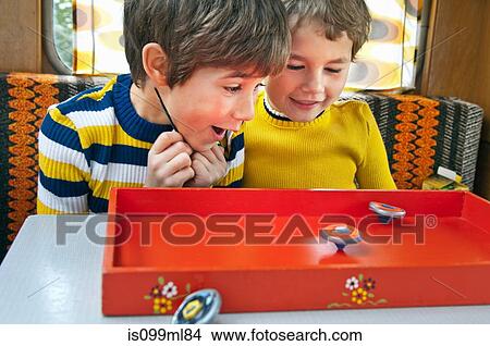 Picture - Two boys playing with spinning tops in caravan. Fotosearch