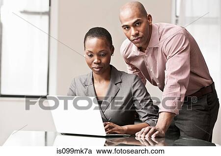 Stock Image - Two business colleagues using laptop. Fotosearch