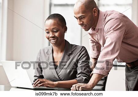 Two business colleagues using laptop View Large Photo Image Stock Image - Two business colleagues using laptop. Fotosearch