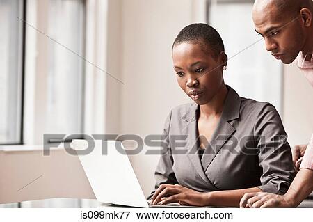 Two business colleagues using laptop View Large Photo Image Stock Photo - Two business colleagues using laptop. Fotosearch