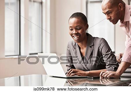 Stock Photo - Two business colleagues using laptop. Fotosearch