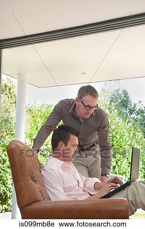 Two businessmen using laptop View Large Photo Image Stock Image - Two businessmen using laptop. Fotosearch