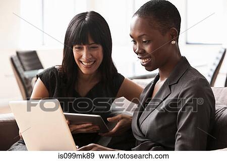 Two businesswomen using laptop View Large Photo Image Stock Photo - Two businesswomen using laptop. Fotosearch