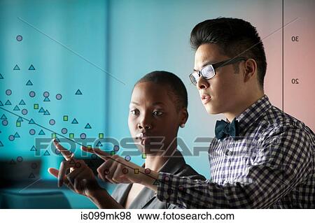 Two people pointing at diagram on window View Large Photo Image Stock Photo - Two people pointing at diagram on window. Fotosearch