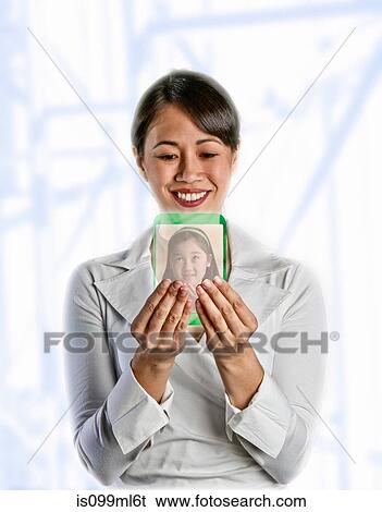 Stock Photograph - Woman looking at image on screen of her daughter. Fotosearch