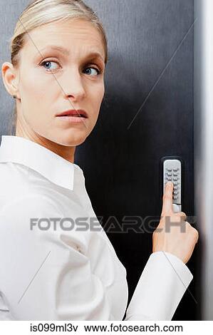 Stock Photo - Woman pressing door keypad. Fotosearch