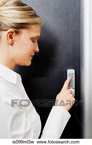 Stock Photo - Woman pressing door keypad. Fotosearch