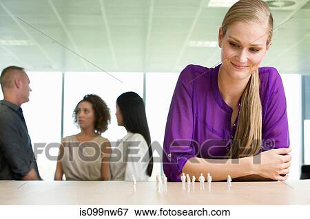 Young architect sitting at desk with model figures View Large Photo Image Stock Photo - Young architect sitting at desk with model figures. Fotosearch