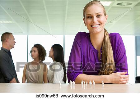 Young architect sitting at desk with model figures View Large Photo Image Stock Photo - Young architect sitting at desk with model figures. Fotosearch