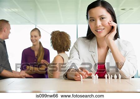 Young architect sitting at desk with model figures View Large Photo Image Stock Photograph - Young architect sitting at desk with model figures. Fotosearch