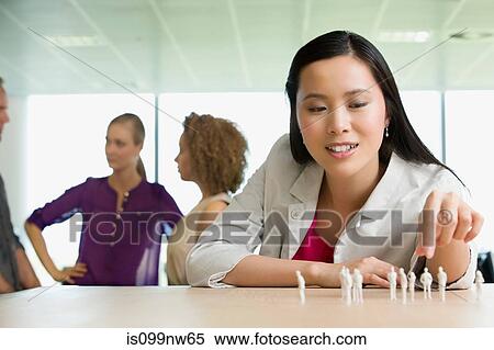 Young architect sitting at desk with model figures View Large Photo Image Stock Photography - Young architect sitting at desk with model figures. Fotosearch
