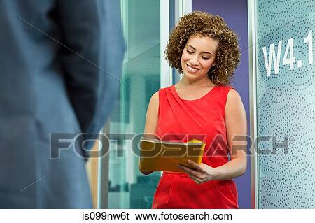Young businesswoman holding file in office View Large Photo Image Stock Photograph - Young businesswoman holding file in office. Fotosearch