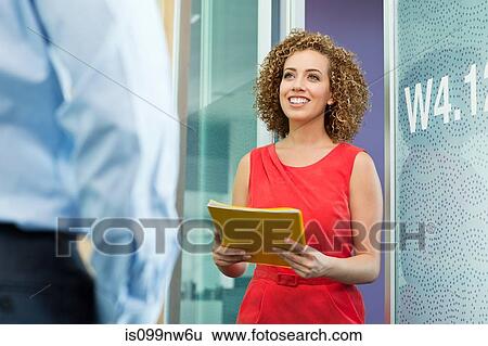 Stock Photograph - Young businesswoman holding file in office. Fotosearch