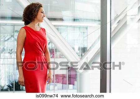 Young businesswoman in red dress in office View Large Photo Image Picture - Young businesswoman in red dress in office. Fotosearch