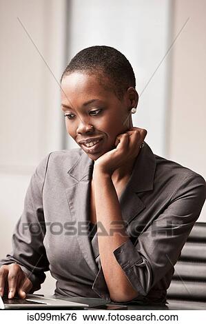 Young businesswoman working at desk View Large Photo Image Stock Photograph - Young businesswoman working at desk. Fotosearch