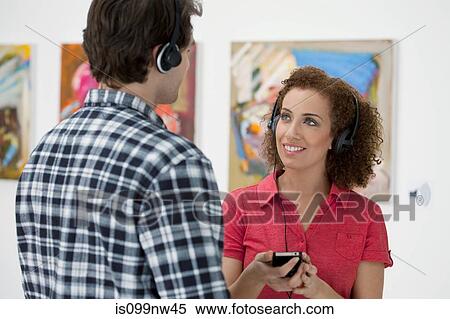 Young couple using audio guides in art gallery View Large Photo Image Stock Photography - Young couple using audio guides in art gallery. Fotosearch