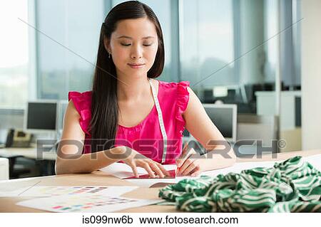Young fashion designer at desk working with green fabric View Large Photo Image Stock Image - Young fashion designer at desk working with green fabric. Fotosearch