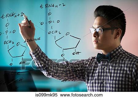 Stock Photography - Young man drawing diagram on window. Fotosearch