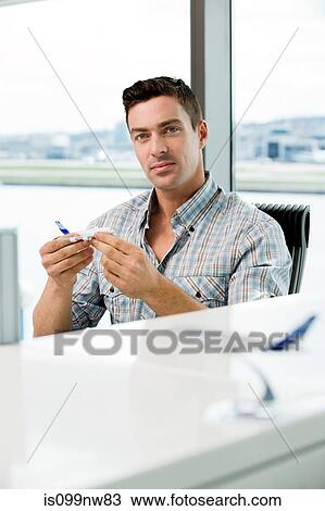 Young man looking at model aeroplane in office View Large Photo Image Stock Image - Young man looking at model aeroplane in office. Fotosearch