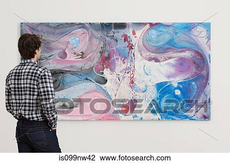 Young man looking at oil painting in gallery View Large Photo Image Stock Image - Young man looking at oil painting in gallery. Fotosearch