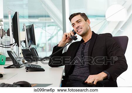 Young man on telephone in IT office View Large Photo Image Stock Photography - Young man on telephone in IT office. Fotosearch