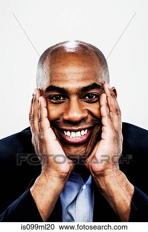 Young man smiling with hands on chin View Large Photo Image Stock Image - Young man smiling with hands on chin. Fotosearch